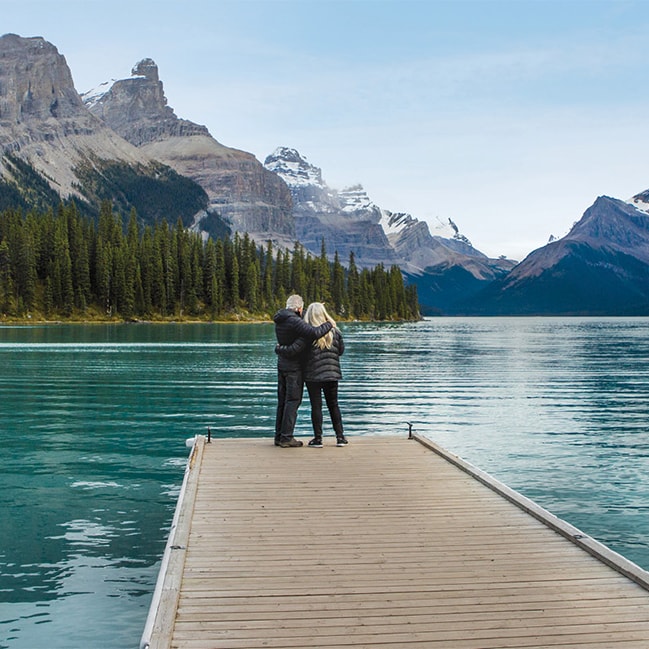 Couple standing at the end of a jetty, Lake Louise, Canada