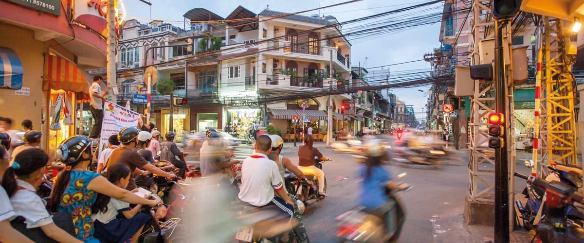 Scooters early evening racing through the streets of Ho Chi Minh City
