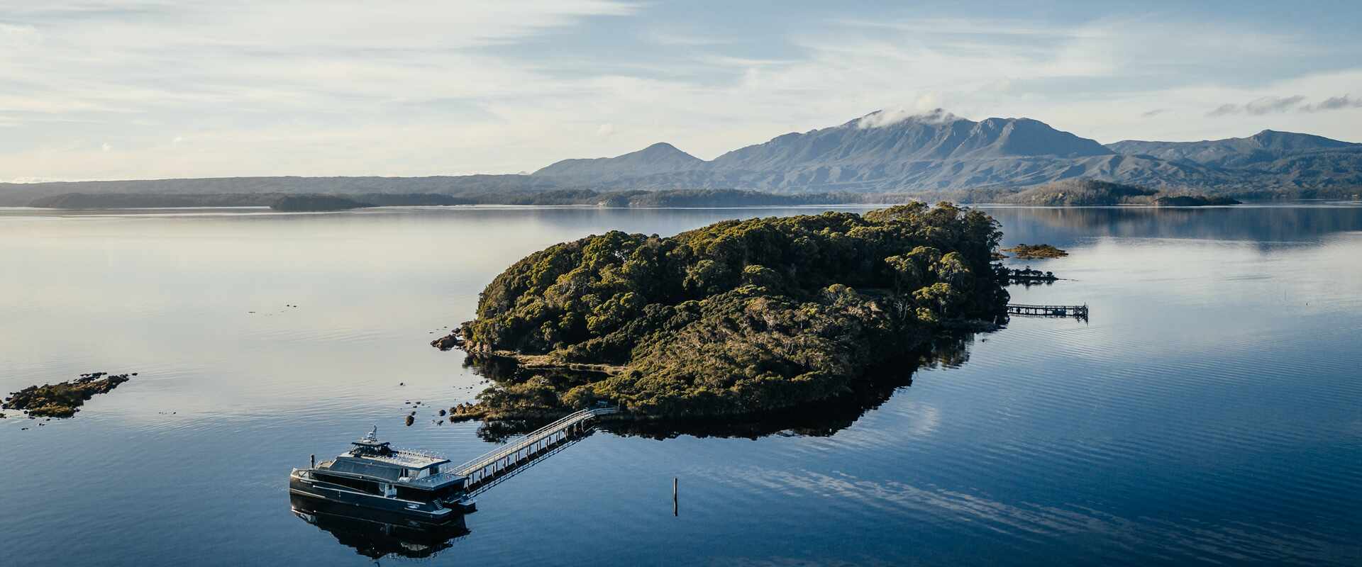 Aerial view of Gordon River catamaran moored at small island, Tasmania