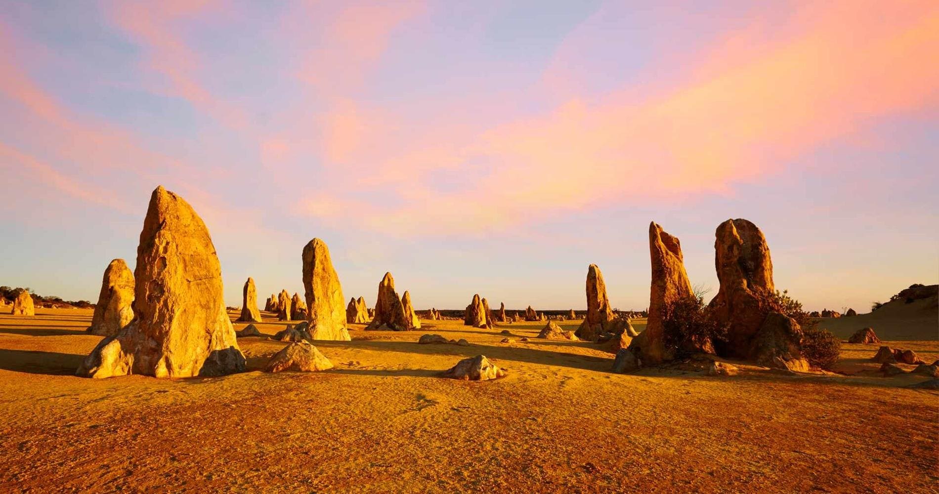 Sunset across a barren landscape with sandstone mounds, Western Australia