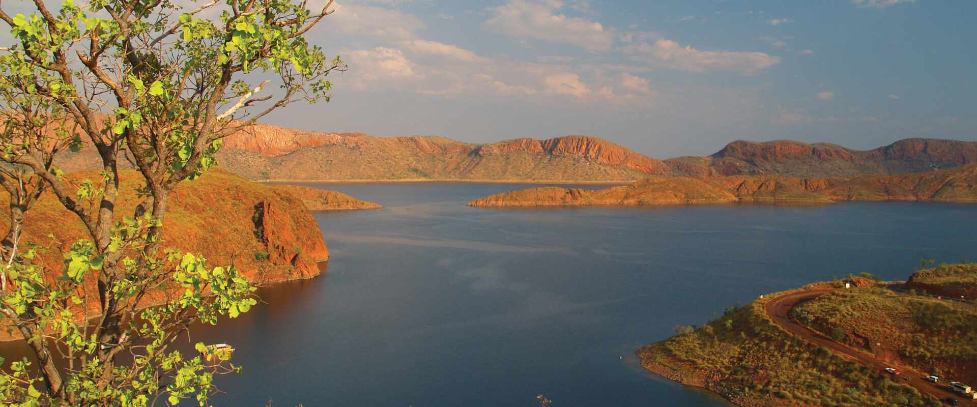 View of blue lake surrounded by orange hills and green tree, Australia