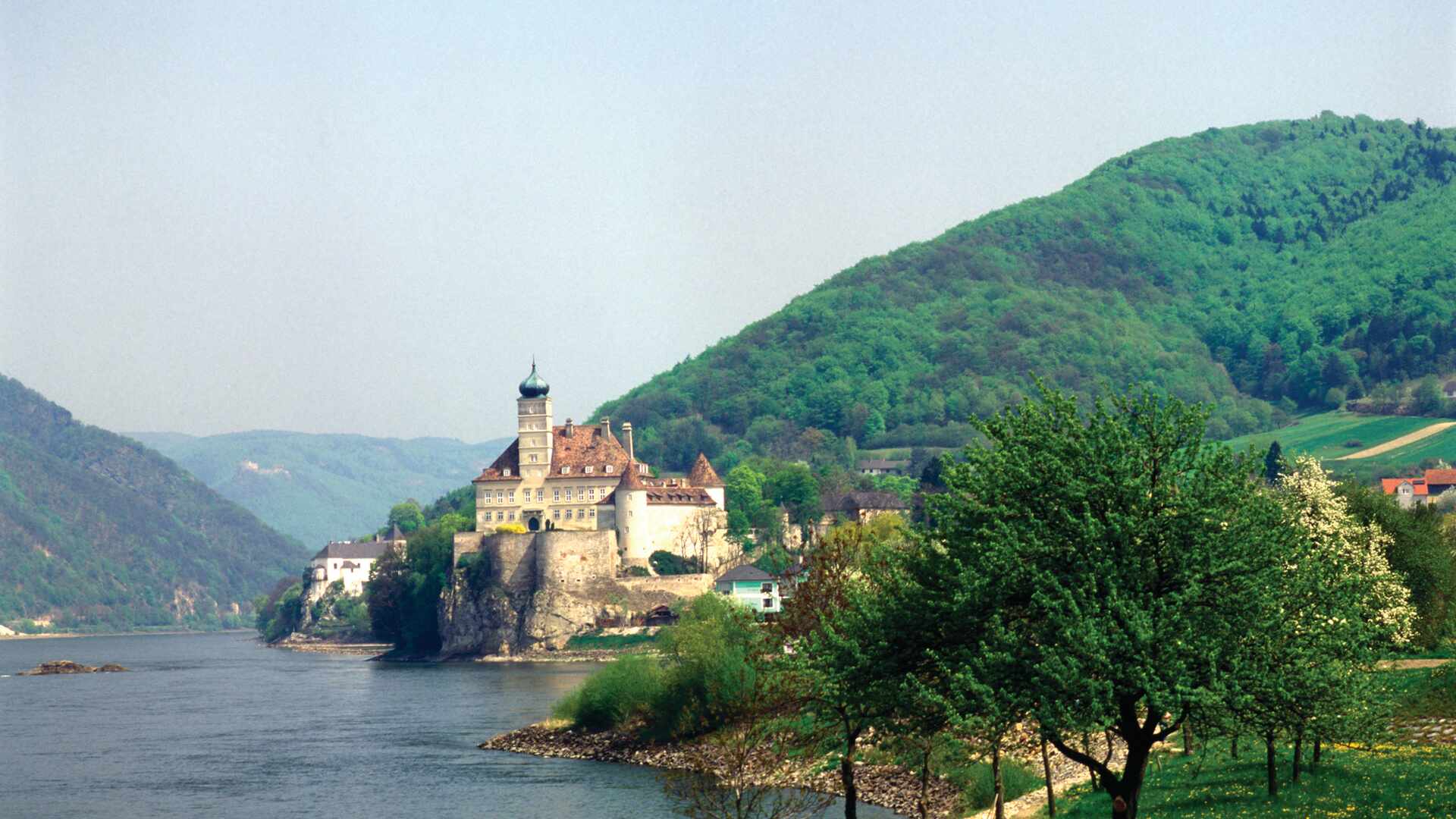 Large castle set high above the banks of a river, Austria