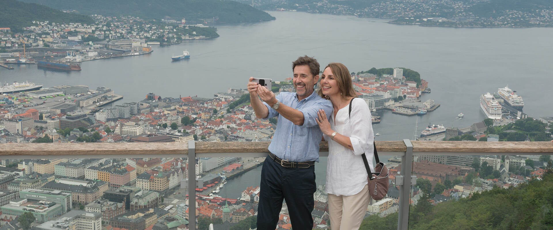 A couple taking a selfie overlooing harbour, Norway