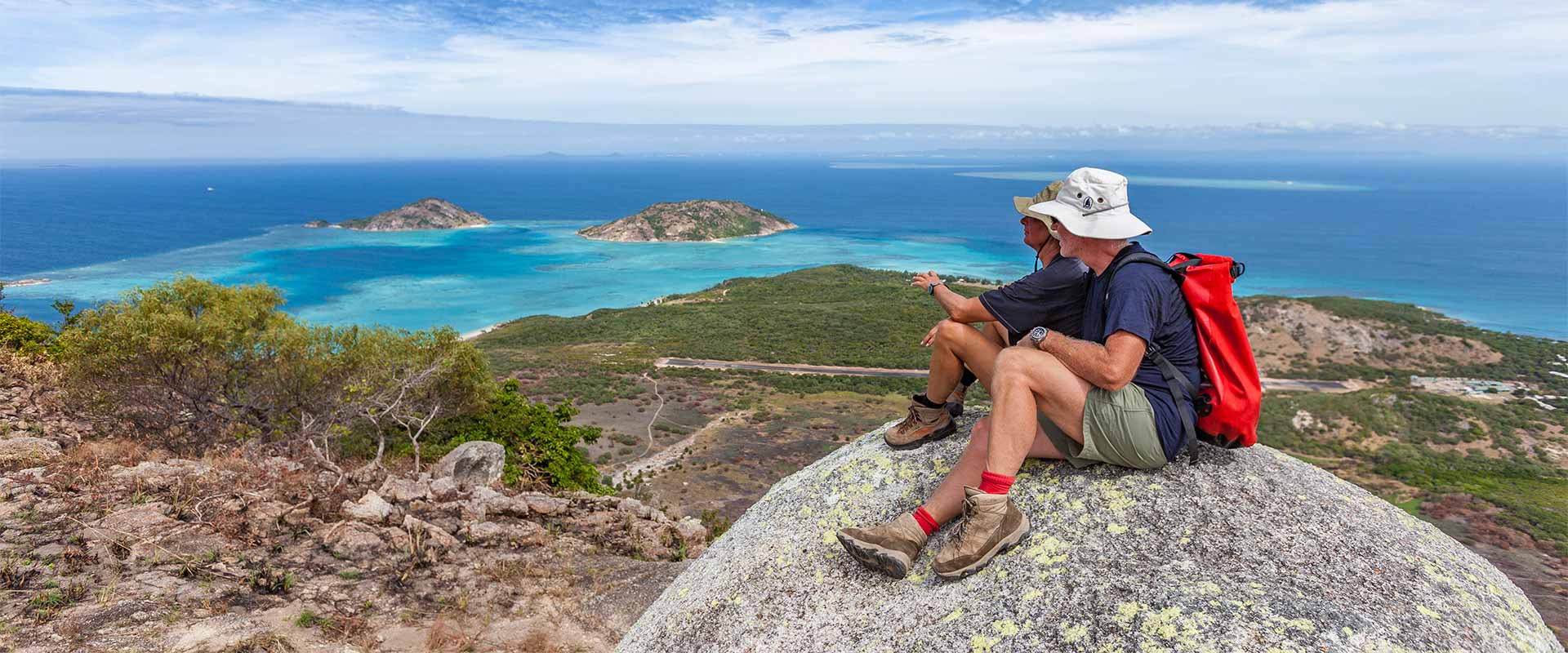Couple sitting on rocks overlooking Lizard Island