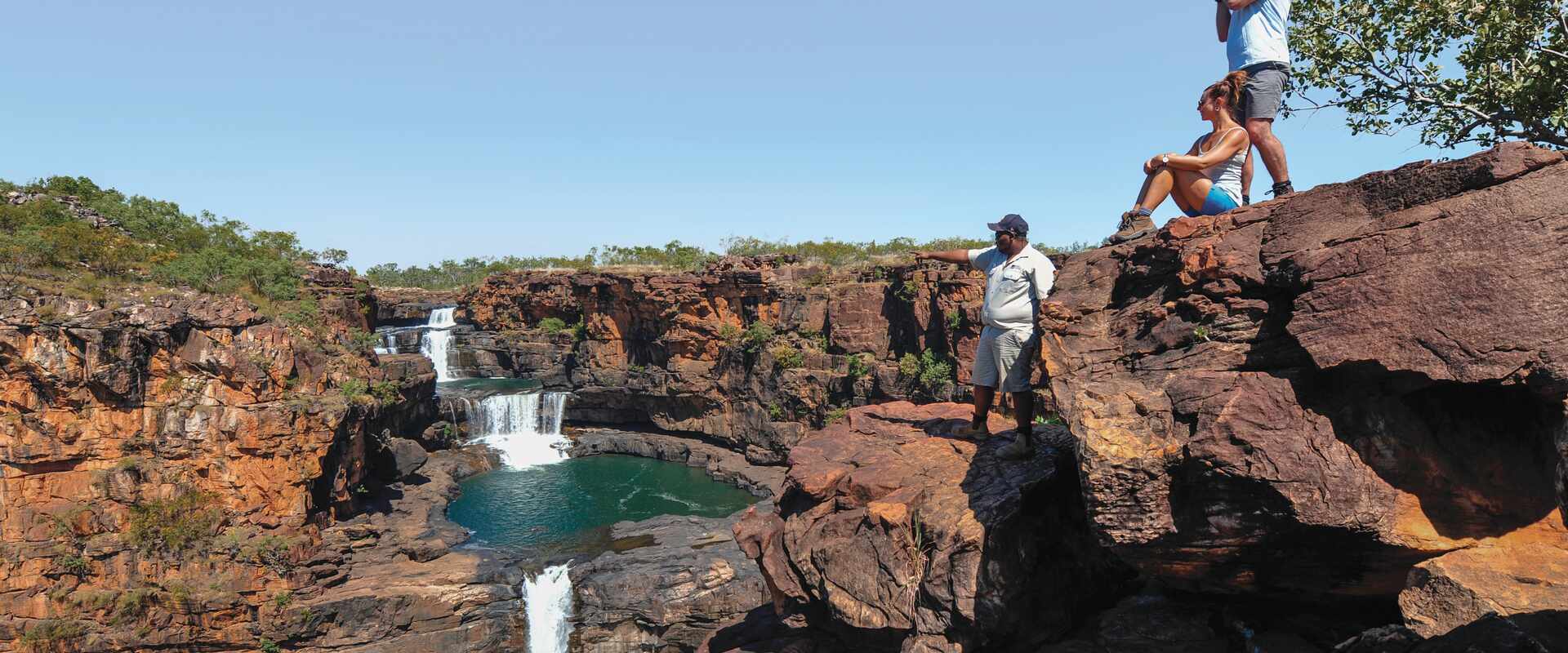 View of two passengers looking over the falls with a guide, Western Australia